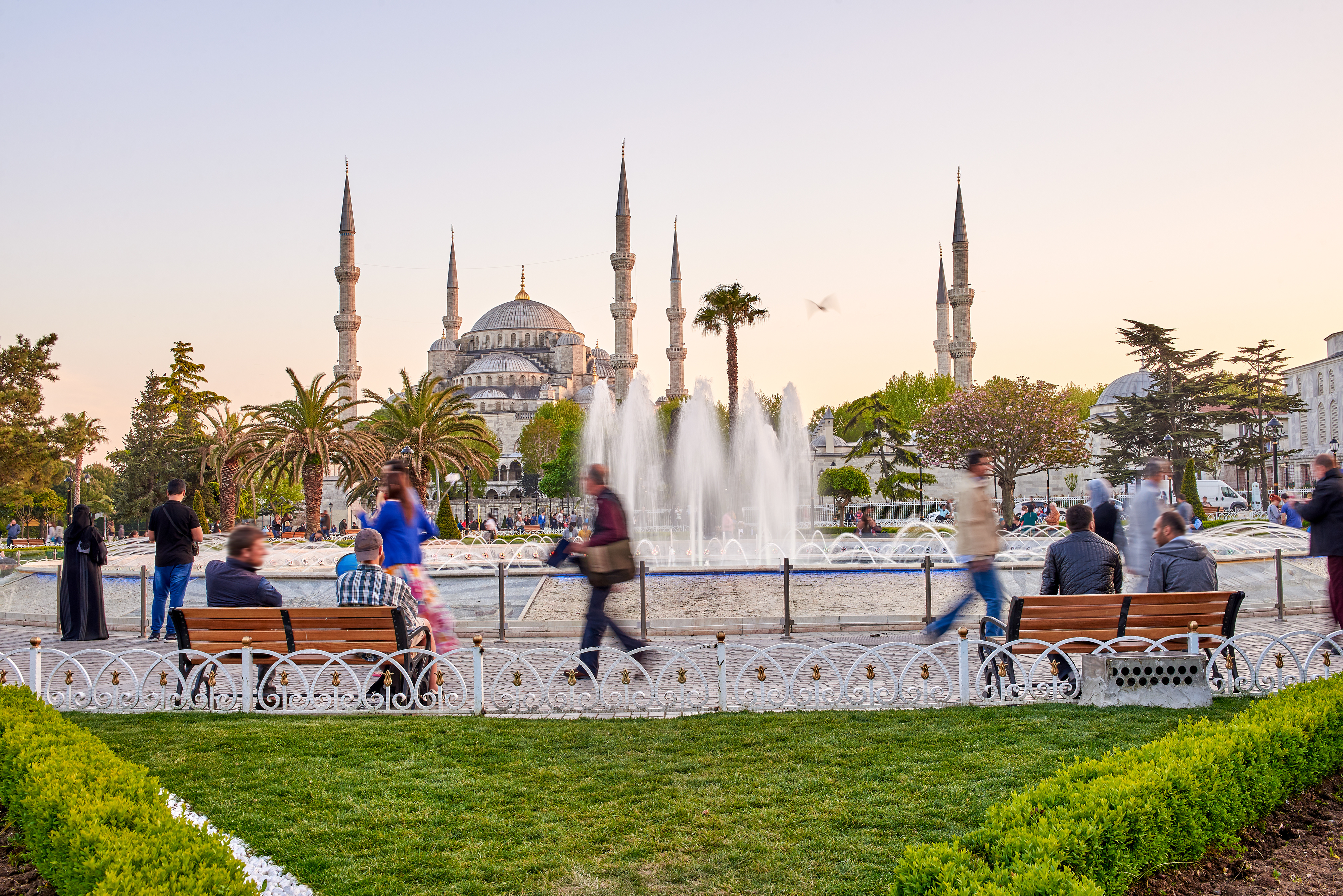 People at the fountain and the Sultan Ahmed Mosque in Istanbul during sunset